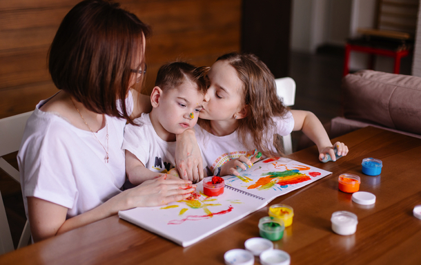 Mutter zeichnet mit Kindern zu Hause. Entwicklung eines Kindes mit Zerebralparese. <br><small>© Antipina - stock.adobe.com</small>